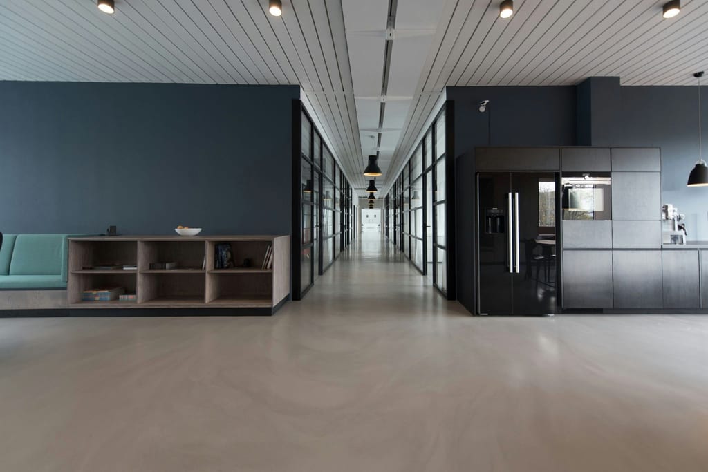 Open-plan office interior with glass partitions and a long corridor